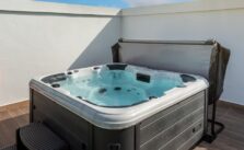 Hot Tub with blue clear water and Cover Lifter in an outdoor home garden