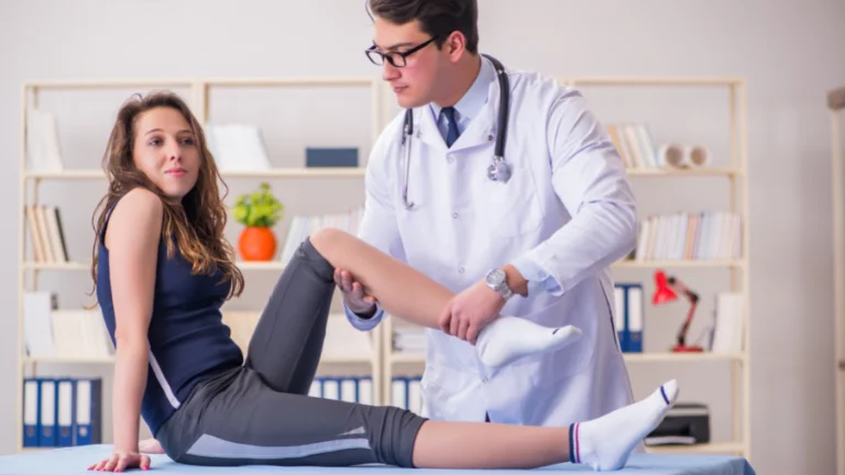 A male therapist doctor administering therapy on a female sportswoman's knee. He applies careful pressure and performs gentle movements to aid in her recovery, while she sits on a therapy table.