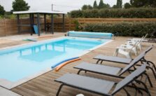 A spacious hot tub with blue water and a relaxing chair placed by the side