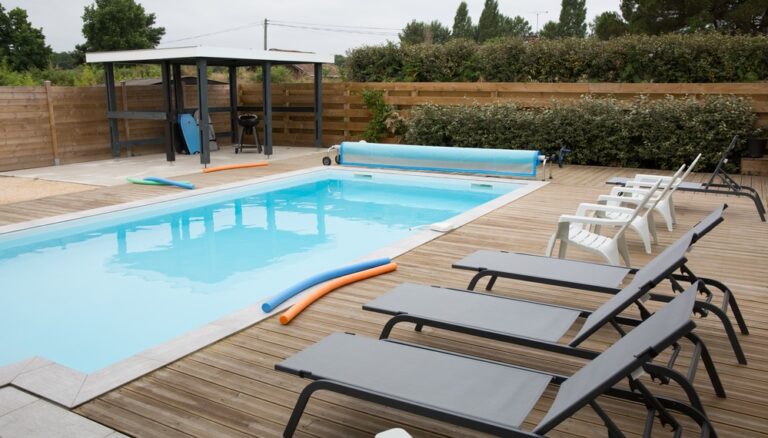 A spacious hot tub with blue water and a relaxing chair placed by the side