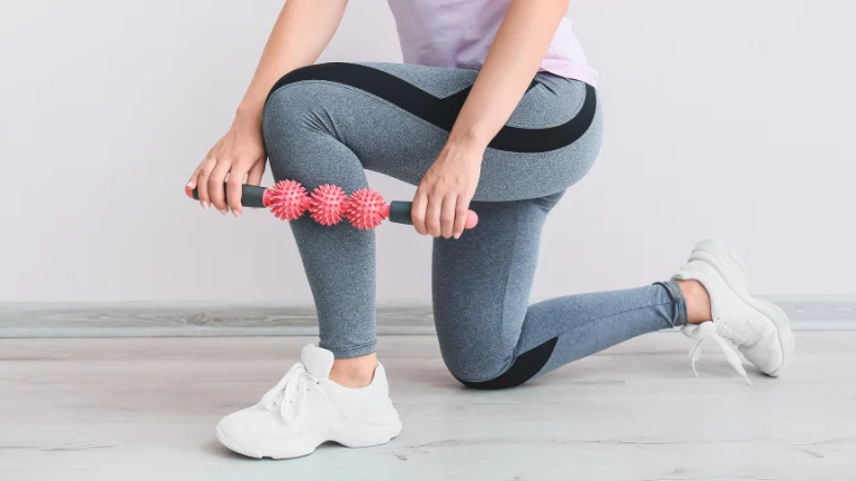 Woman applying a cellulite massager roller to her leg for self-care