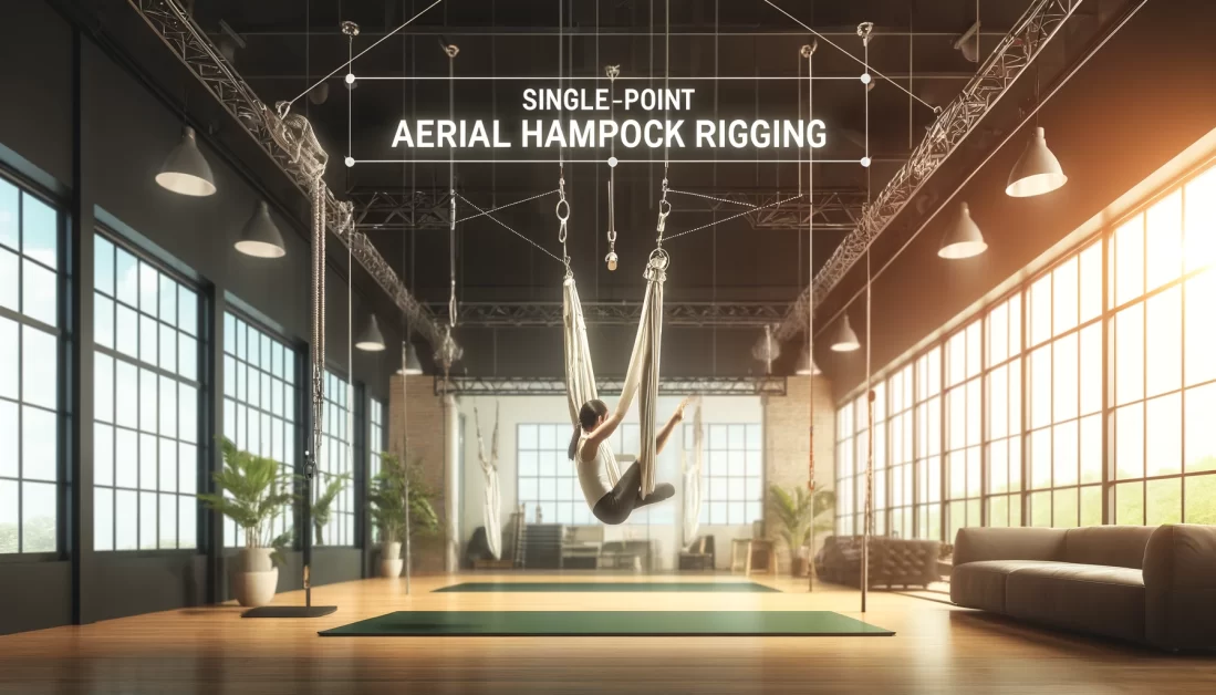 Young woman using a single-point aerial hammock rigging in a well-lit, modern room with large windows, green plants, and padded flooring. Overlay text: 'Single-Point Aerial Hammock Rigging.