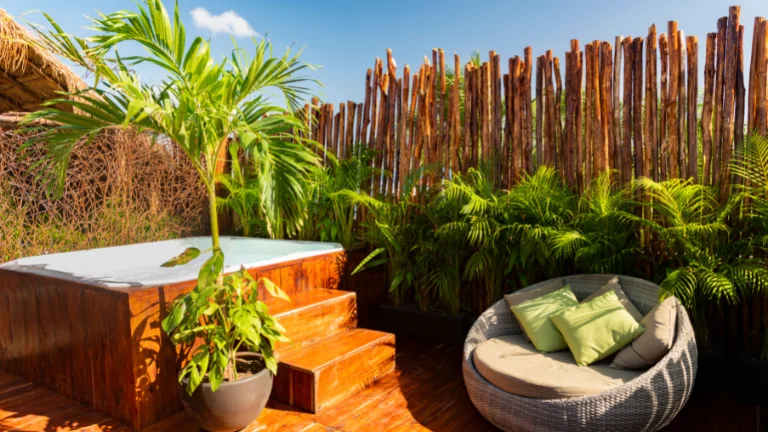 A tropical themed outdoor patio with a hot tub and seating area.