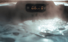 A luxurious hot tub with steam rising from the water, displaying the temperature on a digital panel.