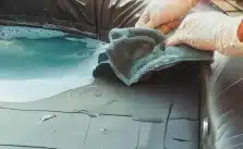 A man cleaning a filled hot tub with a vinyl cover using a soft cloth