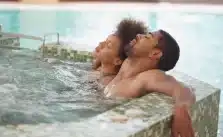 Two young couples enjoying a blissful soak in a hot tub, closing their eyes in pure relaxation.