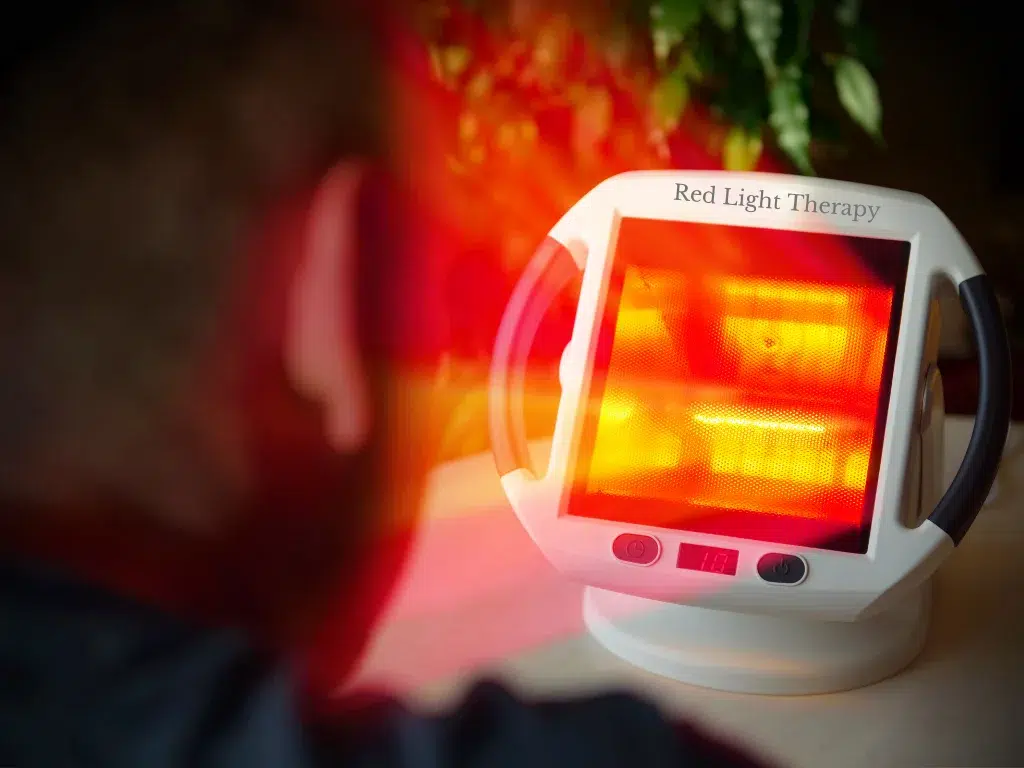 Young man experiencing the benefits of Red Light Therapy with a heater