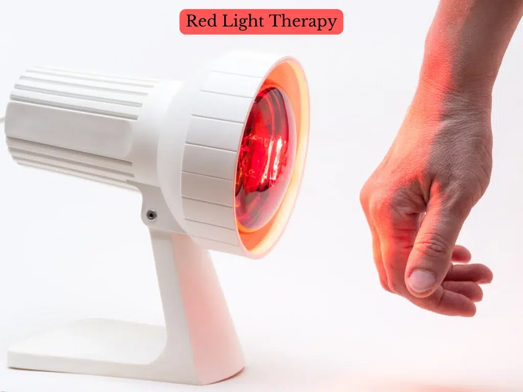 Man receiving targeted Red Light Therapy on his hand with a bulb