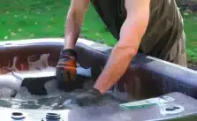 A man fixing the hot tub leaking.