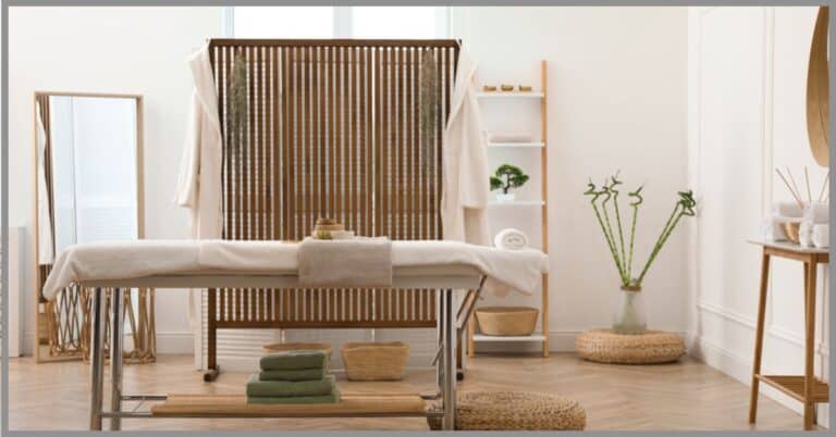 A massage table at a spa, complete with a warmer and all other essential accessories