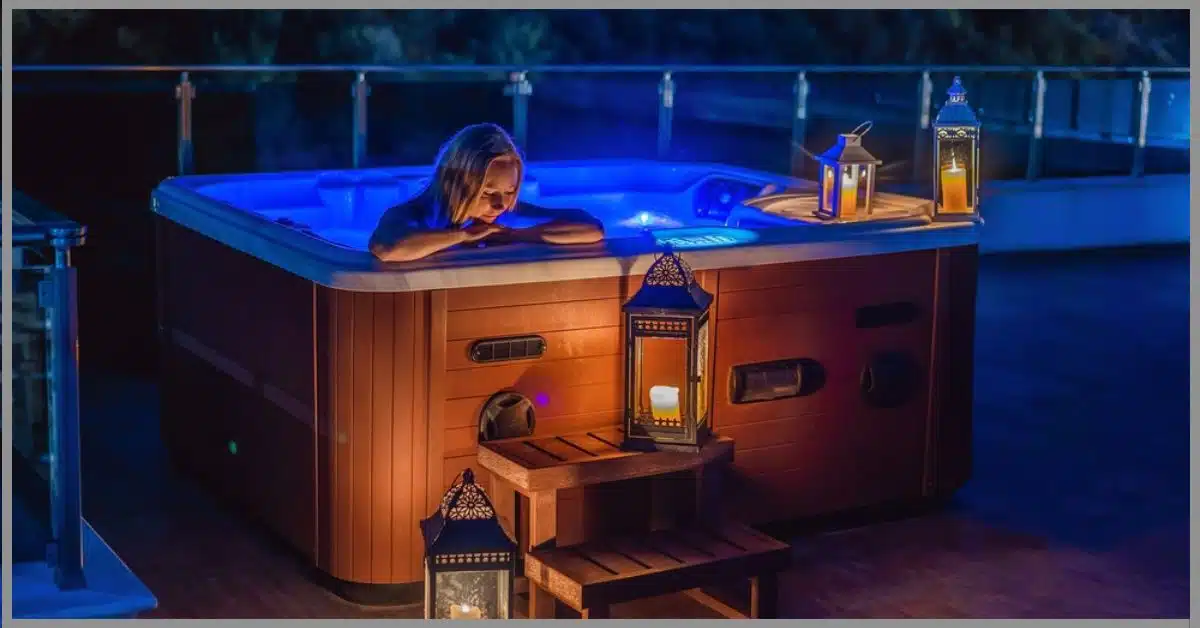 A woman relaxing and alleviating anxiety in a low-lit candlelit hot tub. (Are Hot Tubs Good for Anxiety)