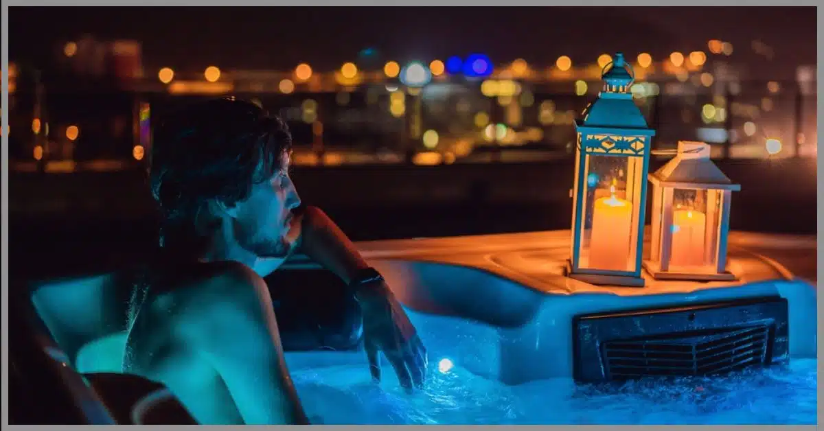 A man relaxing in a low-lit environment with candlelight placed by his side