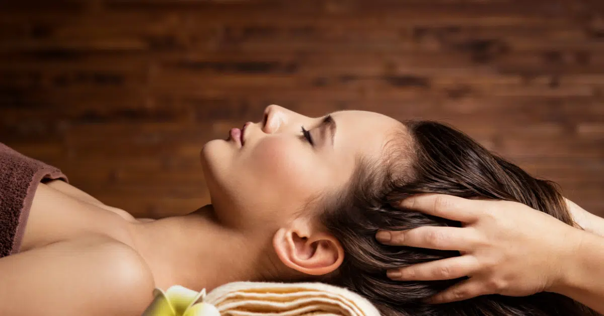 A woman peacefully relaxing with her eyes closed during a Swedish massage for mental health.