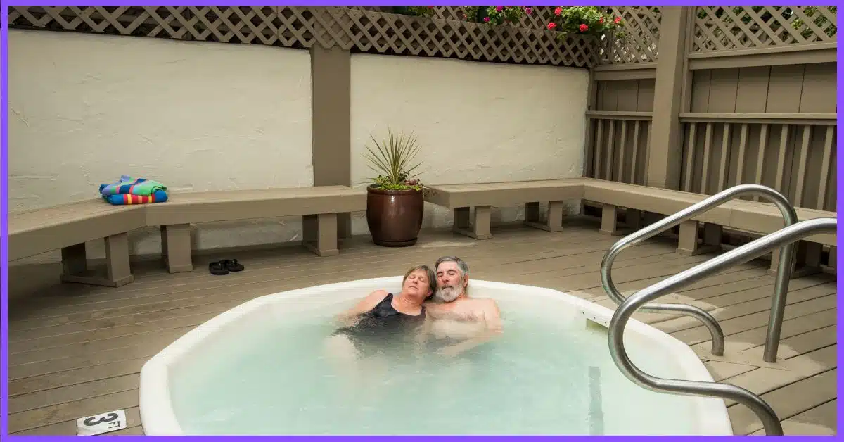 A senior couple relaxing in a hot tub on a wooden deck. (Can You Contract an STD from a Hot Tub)