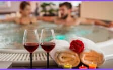 Two people in a hot tub with wine glasses and a city view. Their faces are blurred for privacy.