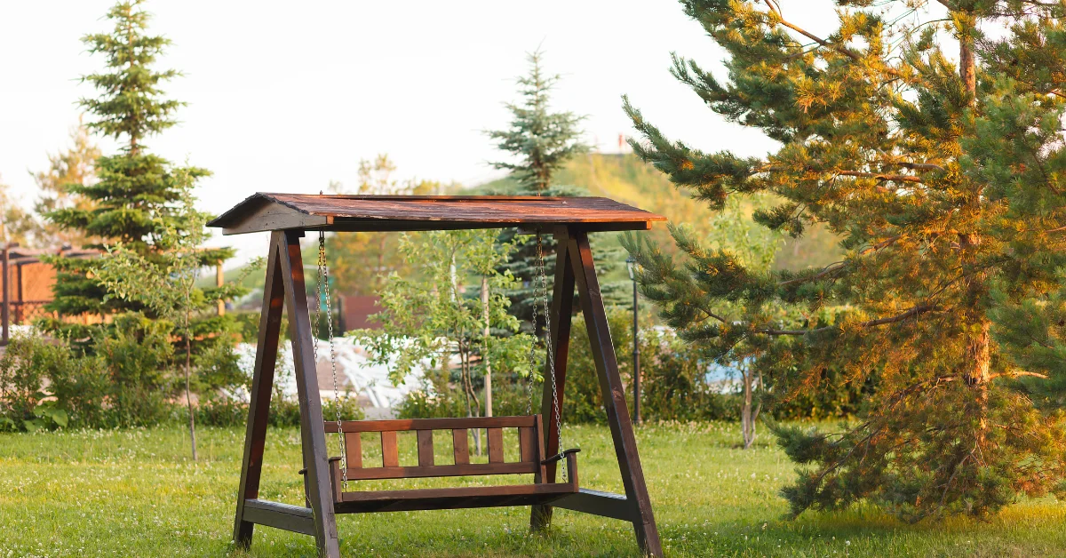 A wooden swing set in a garden view.