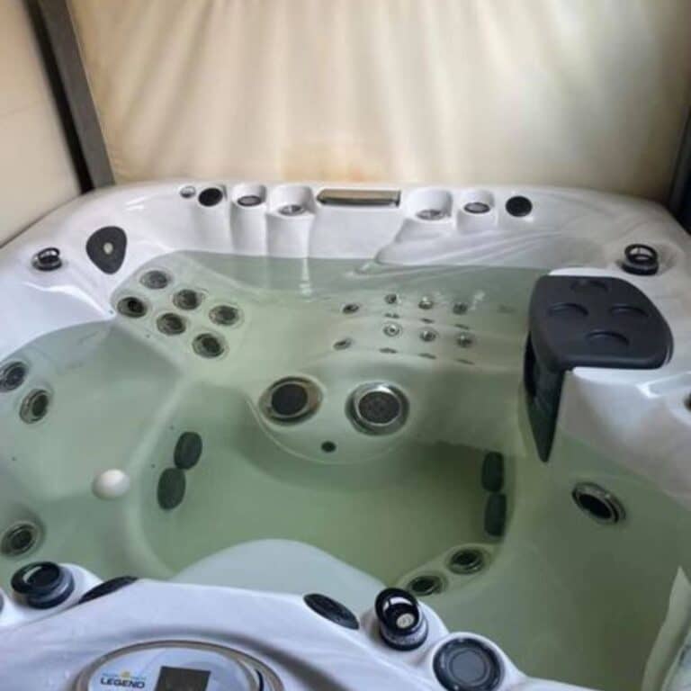 Brown Hot Tub Water: What Causes It and How to Fix It 11 a hot tub with a white interior and black exterior, filled with brown water. (Brown Water in Your Hot Tub)