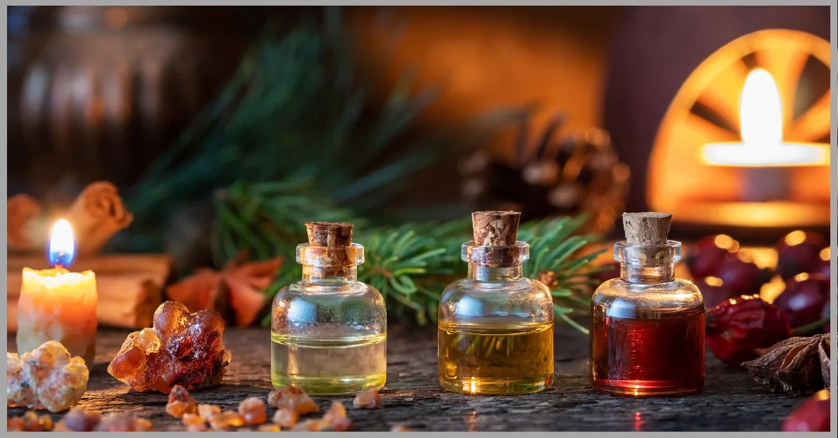 Three bottles of aromatic body oil on a wooden surface with festive decorations.