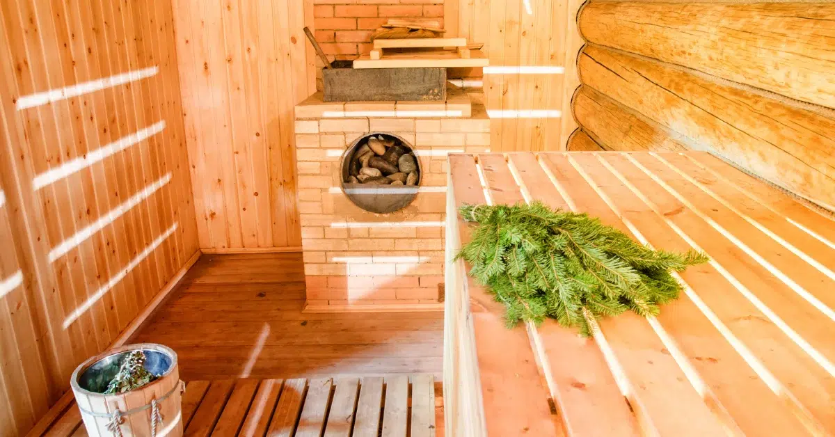 “Interior of a wood-burning barrel sauna with a brick fireplace and wooden benches. (Barrel Sauna Wood Burning)