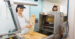 A couple working in a honey forum using Honey Extractor Parts.