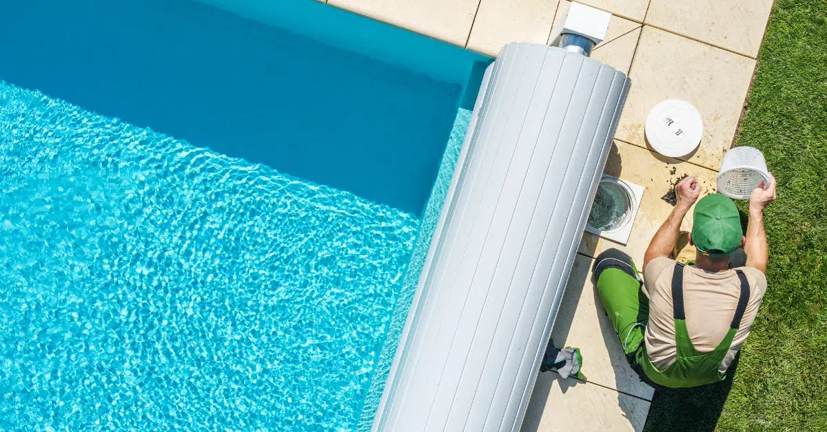 A man cleaning pool sand filter in  blue water.(Pool Sand Filter Cleaning Tips)