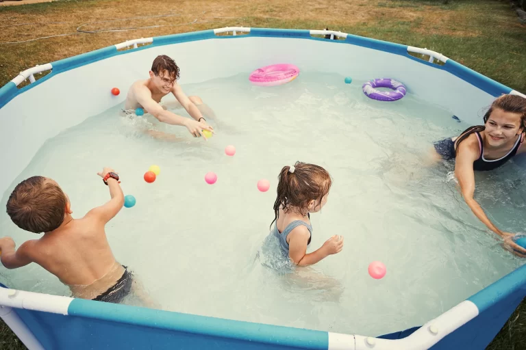 Children happily splashing, jumping, and playing in an inflatable hot tub.