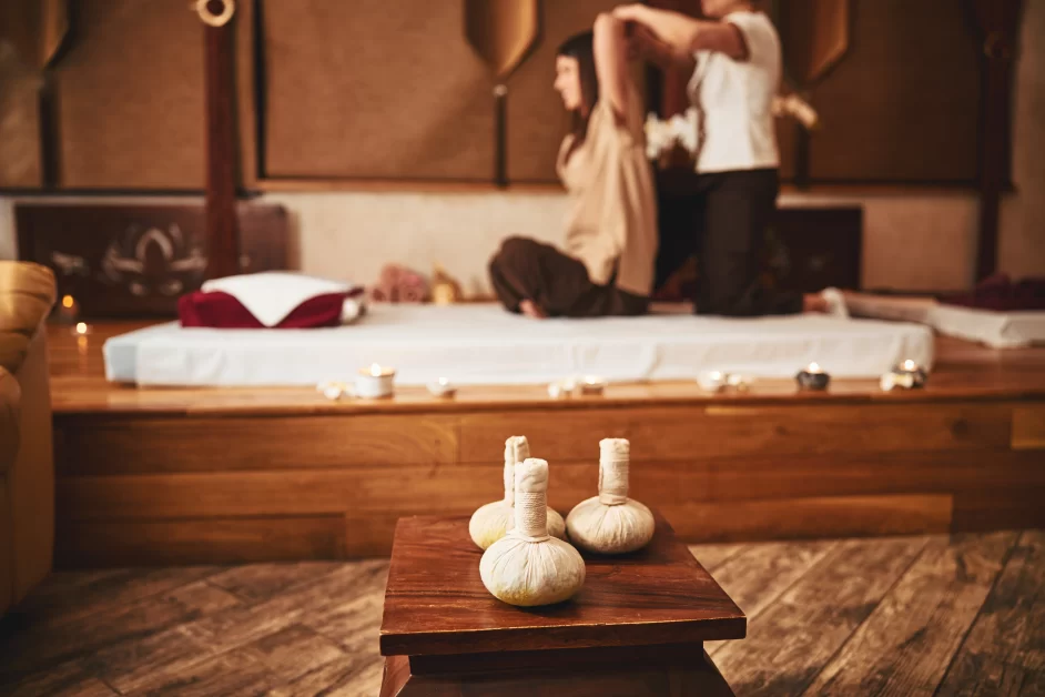  A practitioner performing traditional Eastern massage using foot pressure on a client’s back.