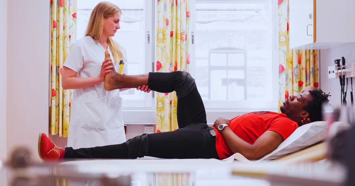 A young man receiving a testicular massage during a medical procedure from a doctor in a clinical setting.